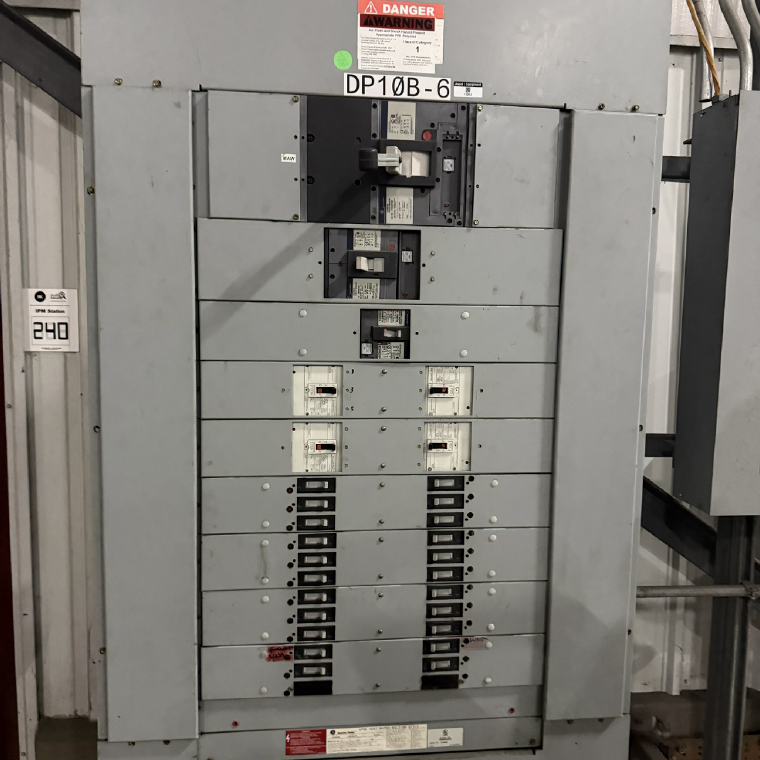 Large commercial distribution panelboard with main breaker and an arc-flash hazard warning label