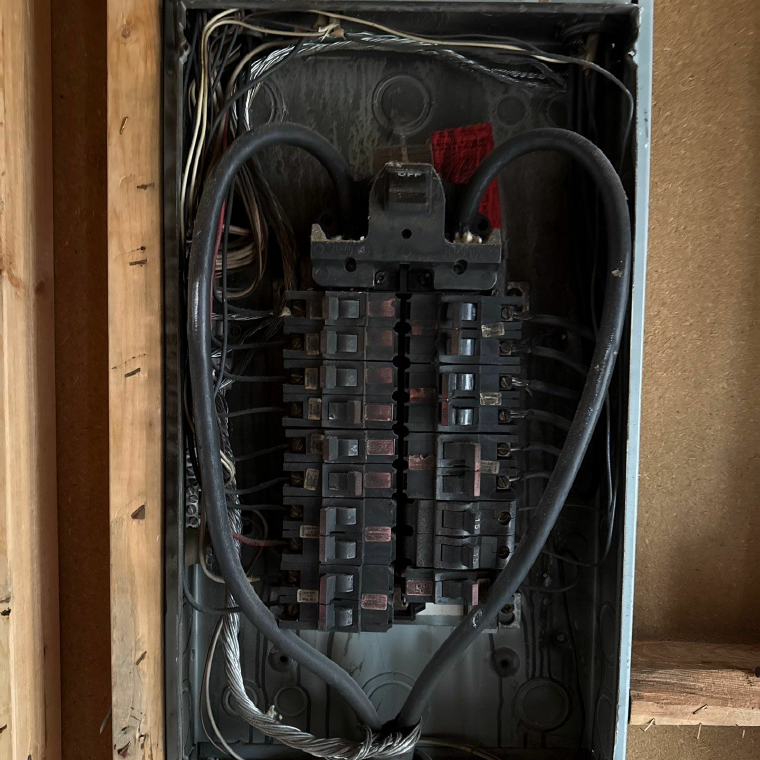 Old residential load center with worn breakers, prior to replacement
